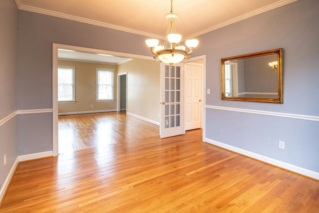 Pièce résidentielle lumineuse avec parquet et lustre, idéale pour les annonces immobilières.