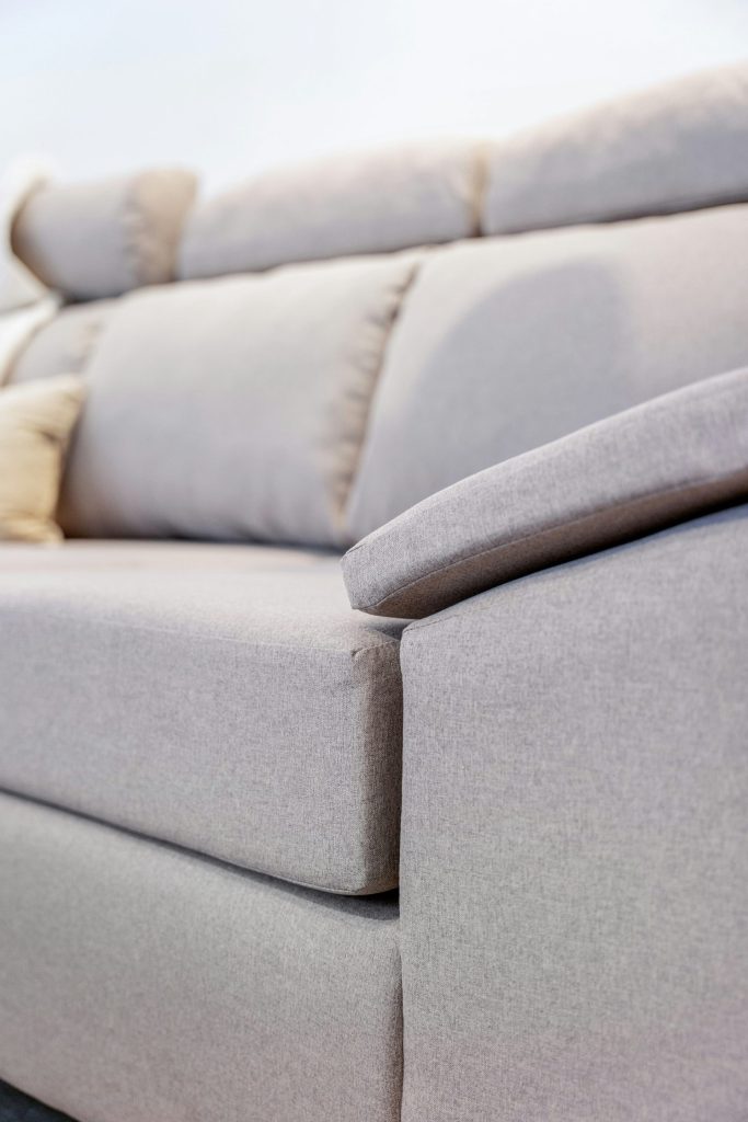 A close-up of a light grey fabric sofa.